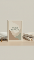 Quiet Resolve paperback memoir, Books photographed at a three-quarter angle on a matte wooden tabletop with soft daylight...