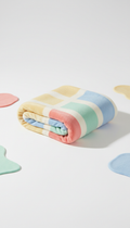 Playful Embrace branded cozy blanket, Hero product shots (care packages/toys/blankets) on seamless Marshmallow background...