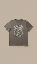 A custom print cotton tee in Charcoal Whisper, perfectly centered on a neutral warm taupe background. Shot with a 50mm...